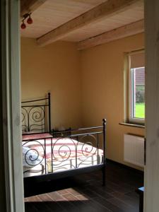 um quarto com uma cama de metal e uma janela em Ferienhaus Suhr em Wittmund
