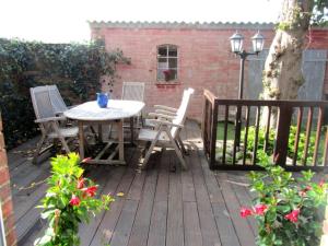 a patio with a table and chairs on a deck at Ferienhaus Suhr in Wittmund