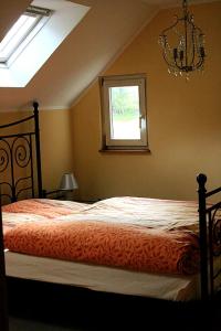 a bedroom with a bed and a window and a chandelier at Ferienhaus Suhr in Wittmund