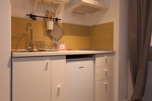 kuchnia z białymi szafkami i zlewem w obiekcie Apartments and Rooms Hey Rovinj w Rovinj +37 zdjęć