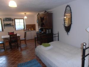 a bedroom with a bed and a kitchen with a table at Hegyestű Apartman in Monoszló