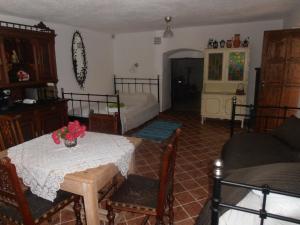 ein Wohnzimmer mit einem Tisch und einem Bett in der Unterkunft Hegyestű Apartman in Monoszló