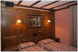 a bedroom with two beds and a picture on the wall at Hotel California in Champoluc