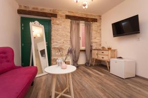 salon z czerwoną kanapą i stołem w obiekcie Apartments and Rooms Hey Rovinj w Rovinj