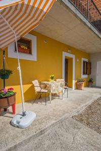 a patio with an umbrella and a table and chairs at Appartment Happy Time in Matulji