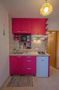 a kitchen with red cabinets and a stove top oven at Appartment Happy Time in Matulji