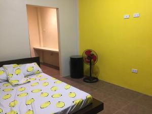ein Schlafzimmer mit einem Bett und einer gelben Wand in der Unterkunft Brown Epitome Lodge in Baler