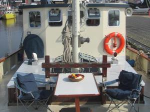 une table et des chaises assises sur un bateau dans l'établissement Zeilschip Fortuna, à Medemblik