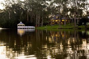 Lincoln Downs Resort Batemans Bay في خليج بايتمانس: منزل مع شرفة في وسط البحيرة