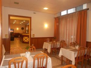 una sala da pranzo con tavoli e sedie e una finestra di Hotel Admitos a Volos