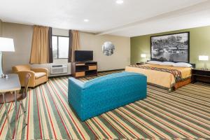 a hotel room with a bed and a couch at Super 8 by Wyndham Bloomington in Bloomington