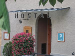 a building with a sign for a hospital with flowers at Hostal La Catalana in Sant Llorenç de Morunys