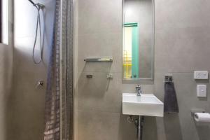 a bathroom with a sink and a shower with a mirror at Breeze Lodge in Brisbane