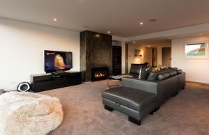 a living room with a couch and a fireplace at Penthouse on Hallenstein by Amazing Accom in Queenstown