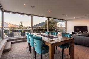 a dining room with a table and chairs and a large window at Views on Hallenstein in Queenstown