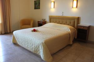 a bedroom with a bed with a flower on it at Athorama Hotel in Ouranoupoli