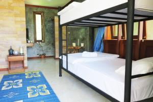 a bedroom with two bunk beds and a blue rug at Wonderland Healing Center in Thongsala
