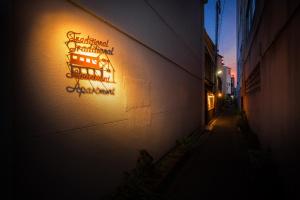 
a neon sign hanging from the side of a building at Traditional Apartment Takamatsu Guesthouse in Takamatsu
