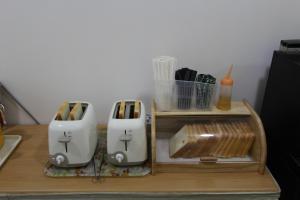 zwei Toaster auf einem Holztisch mit Schneidebrett in der Unterkunft 24 Guesthouse Myeongdong Town in Seoul