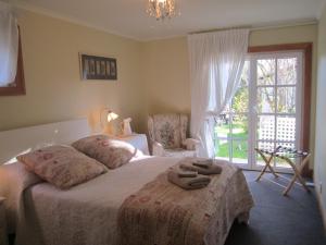 a bedroom with a bed with two towels on it at Magnolia Cottage in Christchurch