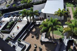 uma vista sobre um quintal com uma piscina e palmeiras em The Bay Apartments em Hervey Bay