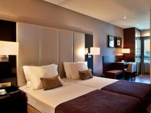 a hotel room with a large bed and a desk at TURIM Luxe Hotel in Lisbon +17 photos