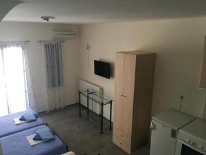 a small room with two beds and a cabinet at Serifos Palace in Livadakia