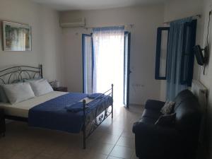 a bedroom with a bed and a couch at Serifos Palace in Livadakia