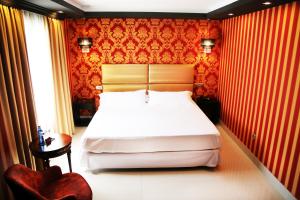 a bedroom with a white bed and a red wall at Hotel Años 50 in Torremolinos