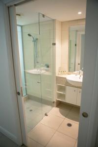 a bathroom with a glass shower and a sink at 6424 BEACH CLUB in Palm Cove