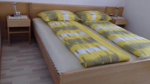 a bed with yellow sheets and pillows on it at Apartment Norma in Bovec