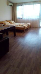 a room with two beds and a wooden floor at Guest House Diamant in Sozopol