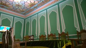 a room with a table and a tv on a wall at Meros B&B in Khiva