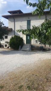 a white house with a green door and a driveway at Hotel Armida in Castenedolo