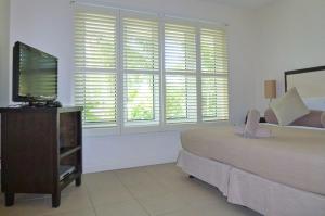 a bedroom with a bed and a flat screen tv at 5231 BEACH CLUB PENTHOUSE in Palm Cove