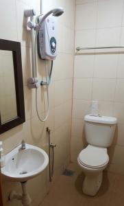 uma casa de banho com um WC e um lavatório em the coconut langkawi em Pantai Cenang