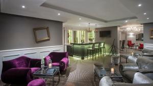 カンヌにあるオテル　シャトー　ド　ラ　トゥールの紫色の家具とバー付きのリビングルーム