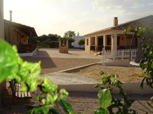 un parque infantil frente a una casa con columpio en casa rural terron, en Alhambra