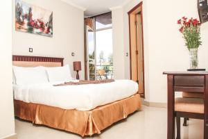 a bedroom with a large bed and a table at Stay Easy Hotel in Addis Ababa
