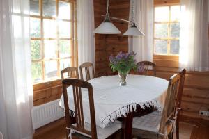 a dining room table with a vase of flowers on it at Toominga Seaside Cottage in Kõiguste