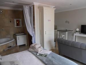 - un salon avec un lit et une baignoire dans l'établissement Bella Vista Self Catering, à Clarens