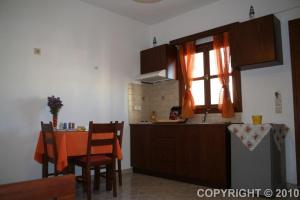 a kitchen with a table and a sink and a window at Margaritis Apartments in Agia Anna Naxos