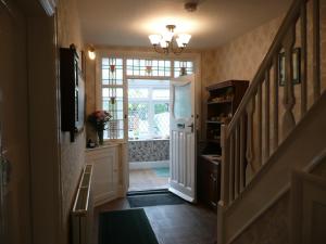 a hallway with a staircase with a door and a window at Cherry Blossom Guest House in Whitby