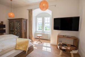 a bedroom with a bed and a flat screen tv at Schloss Spangenberg in Spangenberg