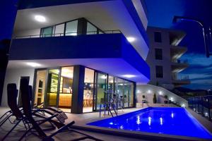 a house with a swimming pool in front of a building at White Cloud Apartments in Korčula