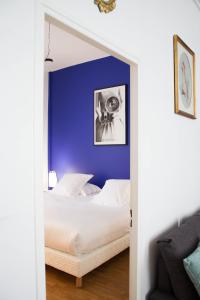 a bedroom with a bed with a blue wall at Appartements de Jeanne in Lille