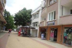 a person walking down a street next to buildings at Guest Rooms Colours in Kazanlŭk