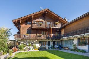 a large house with a balcony and a yard at apartment EFEU "mit stil & tradition" in Grächen