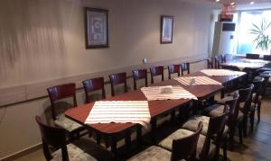 una sala da pranzo con tavoli e sedie in legno di Family Hotel Kartala a Blagoevgrad