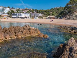 einen Strand mit einer Gruppe von Menschen im Wasser in der Unterkunft Golden Mar Menuda in Tossa de Mar